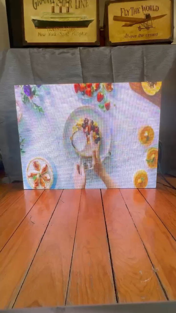 El mismo muro de madera mostrando contenido a todo color: la pantalla Morphix encendida